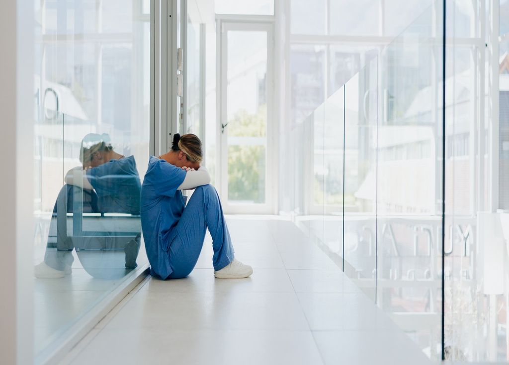 trabajador de la salud, sentado en el suelo, con aspecto afligido y cansado trabajador de la salud, sentado en el suelo, con aspecto afligido y cansado